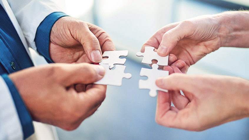 person and doctor holding puzzle pieces