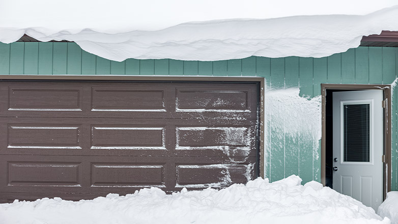 garage with snow on roof
