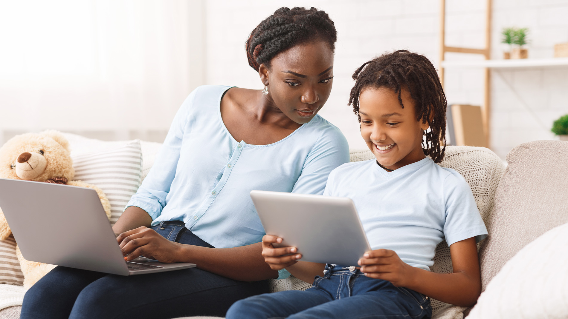 african american mother and son playing on a tablet together smiling