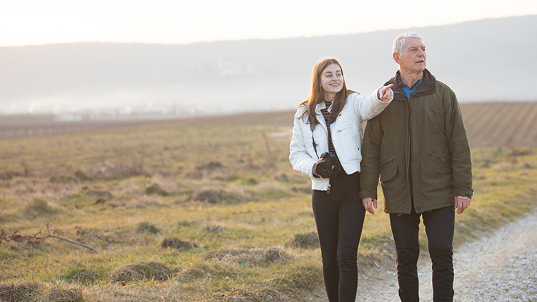 grandfather and granddaughter walking along a path