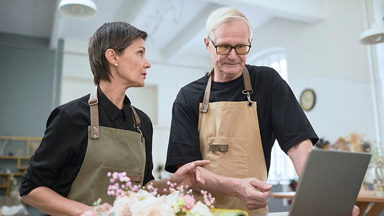 Couple business owners looking at laptop