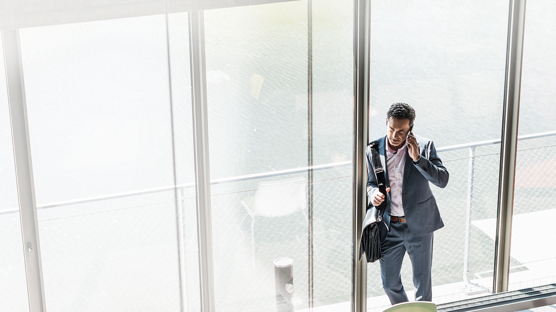 Man standing at the door of his office talking on the phone.