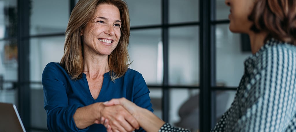 JFG advisor shaking hands with a professional services business client.