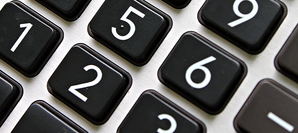 Angled close-up of a calculator keypad with white numerals on black square keys.