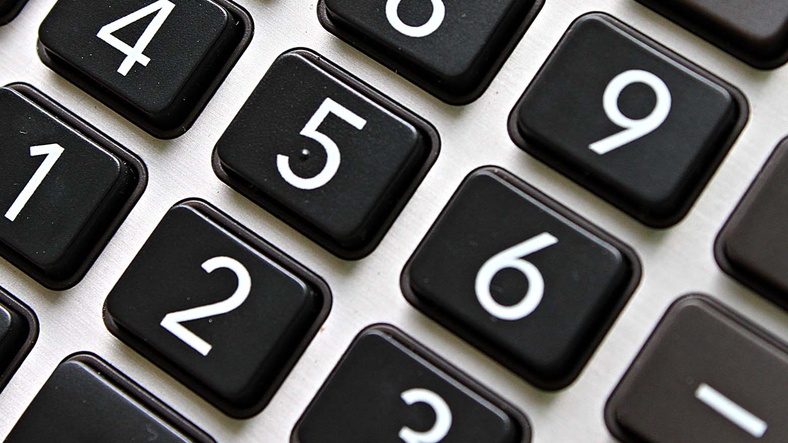 Angled close-up of a calculator keypad with white numerals on black square keys.