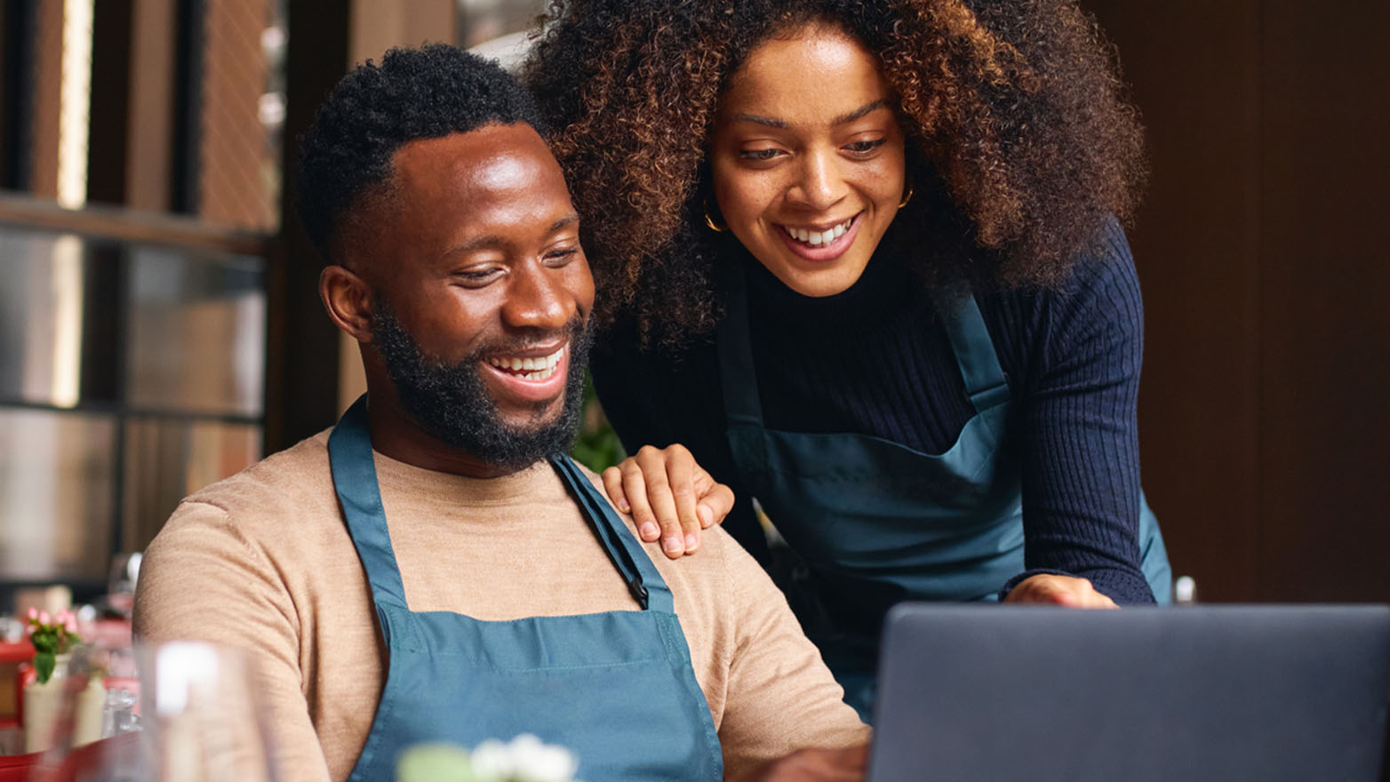 Small business owners reviewing JFG business credit cards on a laptop.