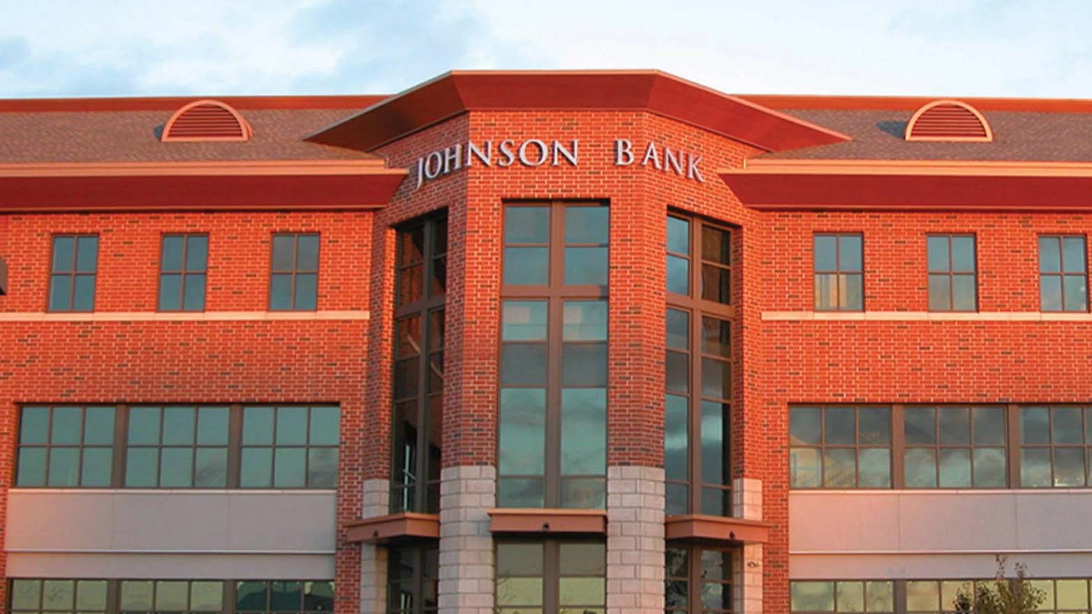Exterior of the Johnson Bank, a multi-story red brick building with a curved central facade.