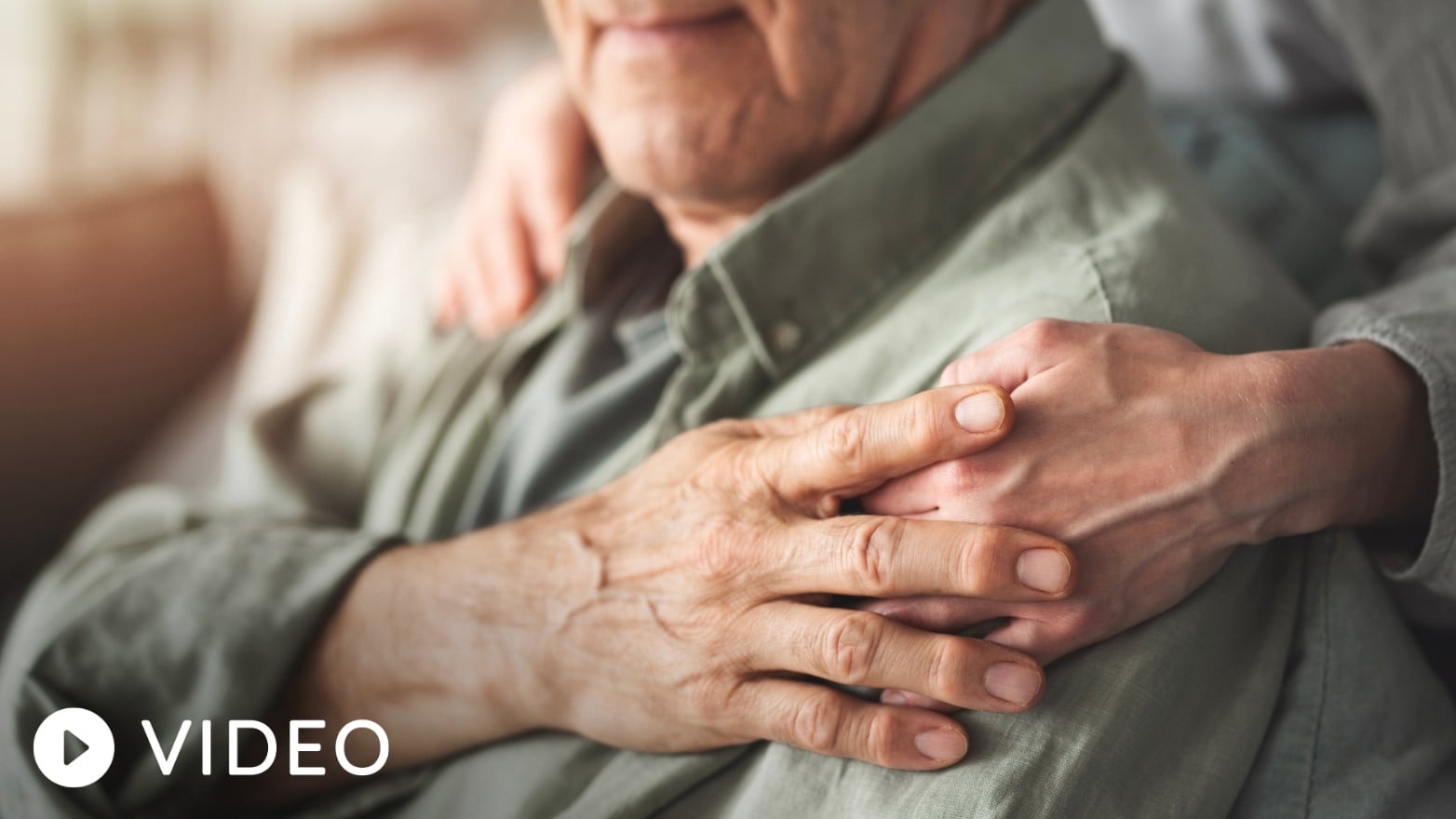 Close-up of an older adult’s hands being gently held by another person, symbolizing support and care during conversations about Social Security benefits and retirement income planning.