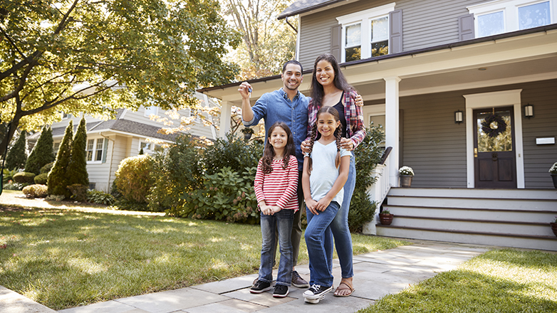 family standing in front of new home