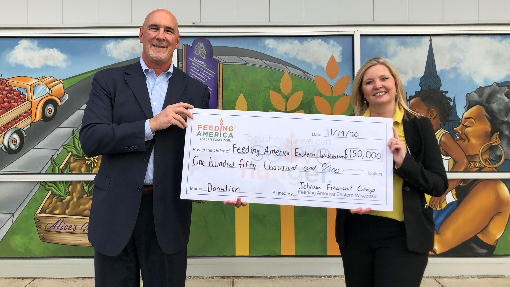 JFG CEO Jim Popp presents donation to Patti Habeck CEO of Feeding America Eastern Wisconsin