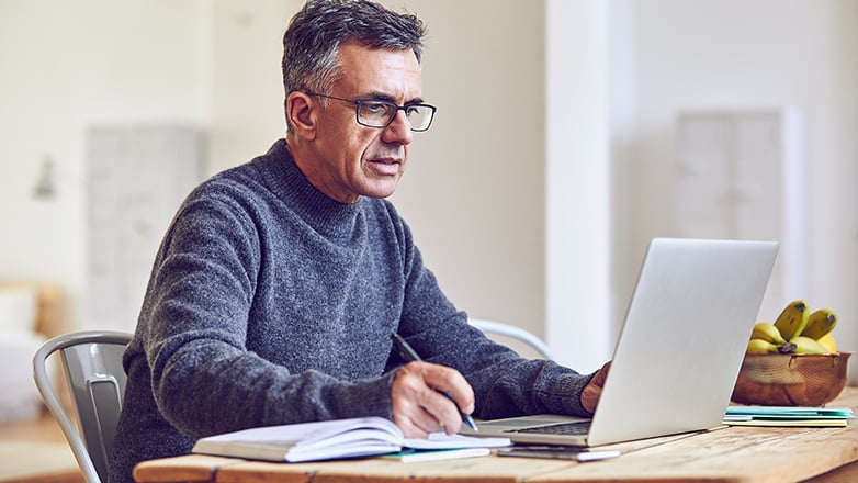 male professional at table working on laptop