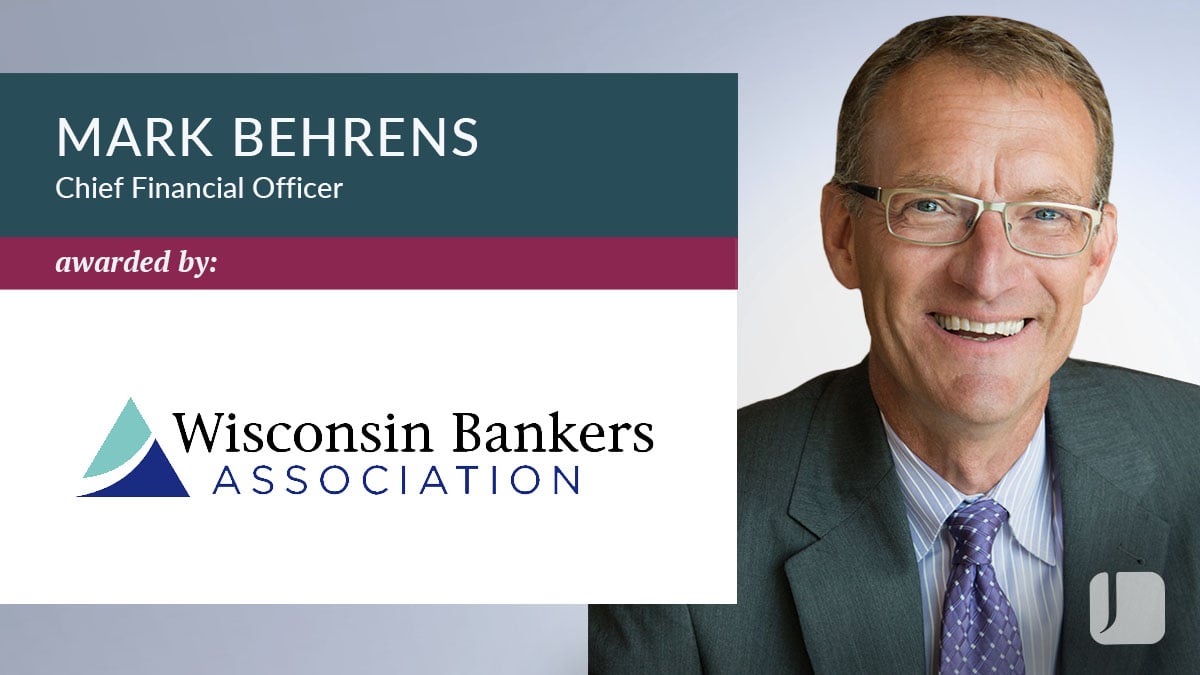 Recognition graphic featuring a professional head‑and‑shoulders portrait on the right and text on the left reading “Mark Behrens, Chief Financial Officer,” with “awarded by Wisconsin Bankers Association” and the association logo.