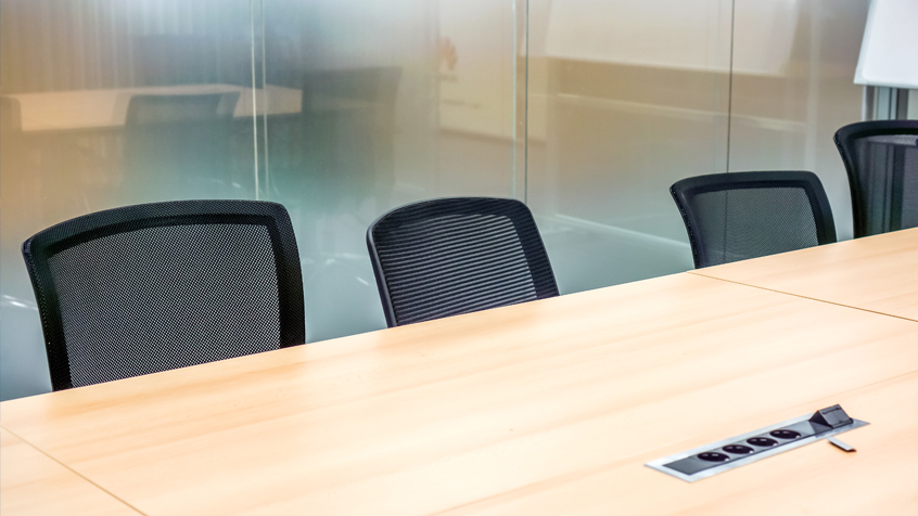 empty conference room with a conference table and desk chairs.