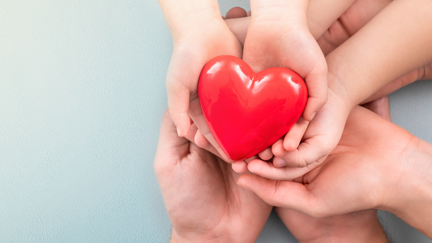 three sets of hands holding heart