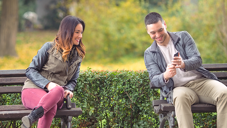 Couple looking at a phone in the park