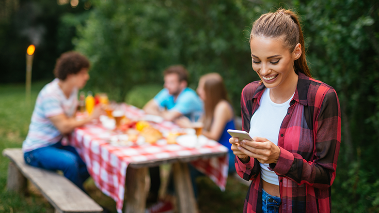 Female enjoying a picnic looking at her phone