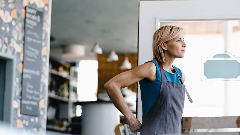 Small business owner opening her door, ready for business.