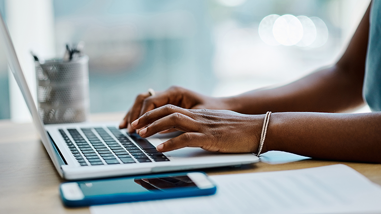 hands of an african american woman using a laptop.