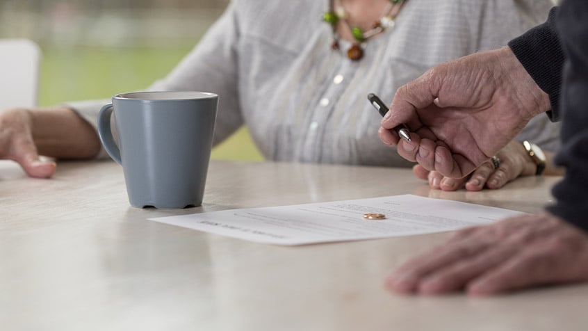 elderly couple signing divorce papers