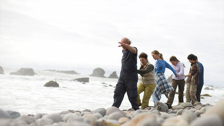 Family walking together along the shoreline.