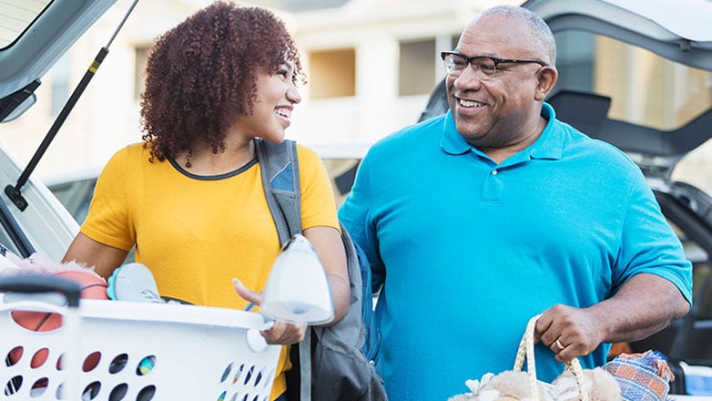 A father helps his daughter move into her college dorm.