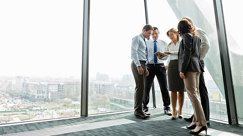 Group of employees looking at the plans in their new office space.