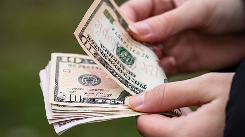 two hands holding cash