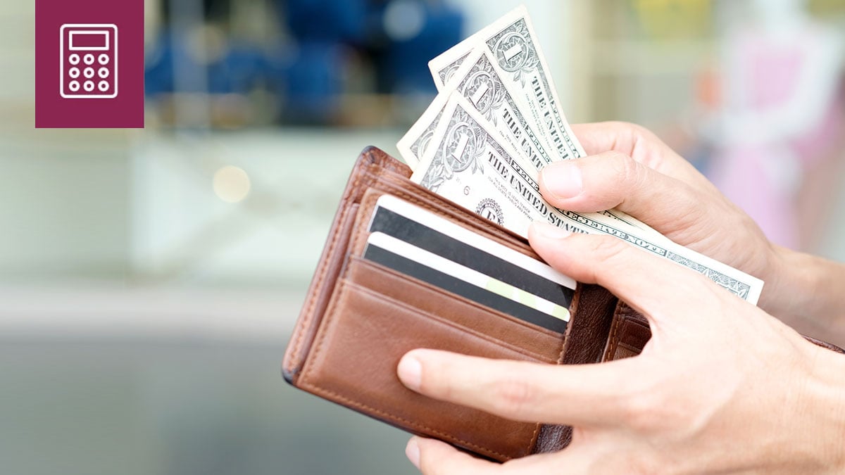 Close-up of hands removing bills from their wallet.