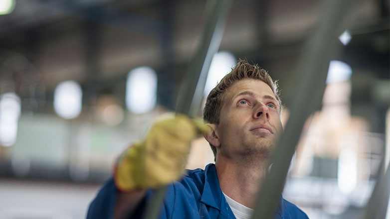 Man working with large equipment in a manufacturing facility.