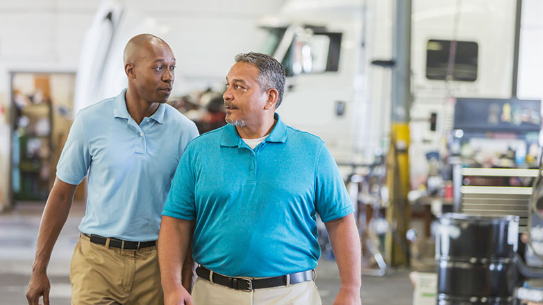 Two men wlaking through their trucking company.