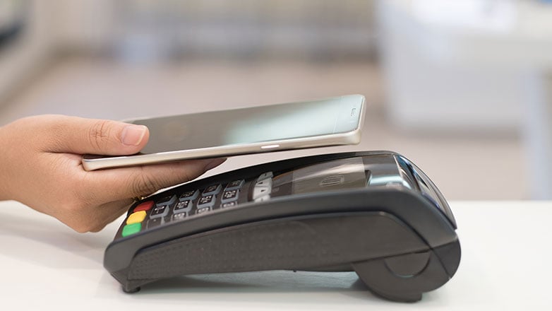 Person using mobile phone to pay with a credit card.