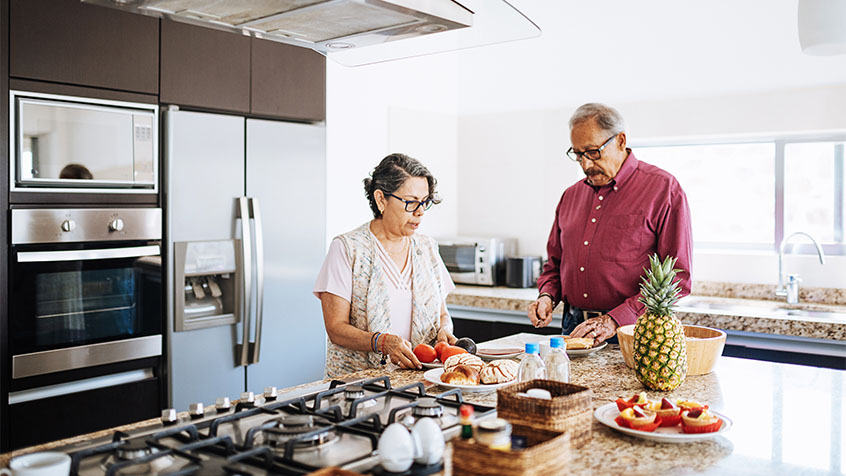 older couple preparing food in an upscale kitchen