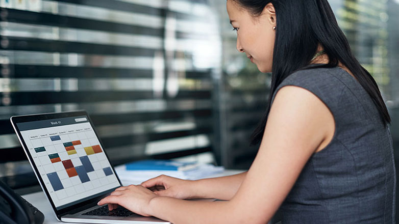 Woman checks the calendar on her computer at work.