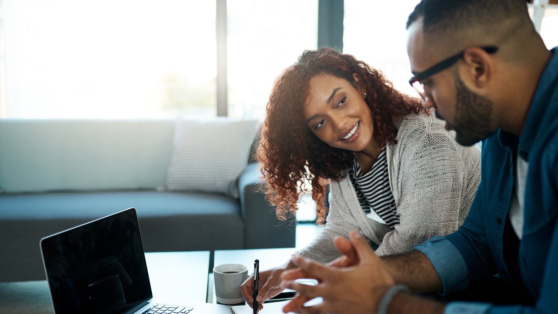 couple having discussion at table with laptop