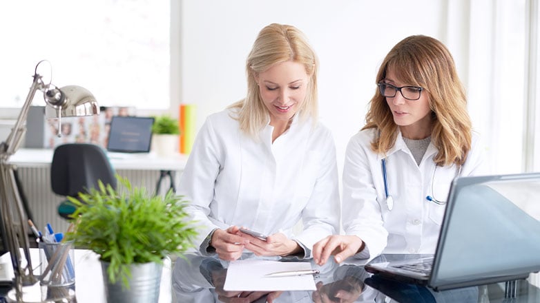 advisor meeting with doctor at desk with laptop