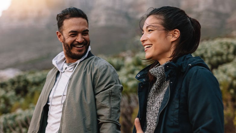 couple smiling at each other on hike