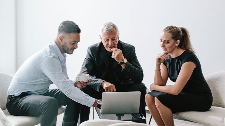 man and son meeting with advisors at table looking at computer