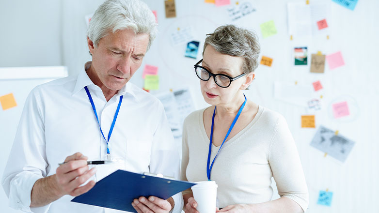 man and woman solving problem on clipboard