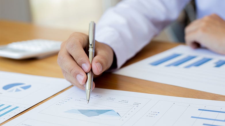 Man pointing to graphs with a pen.