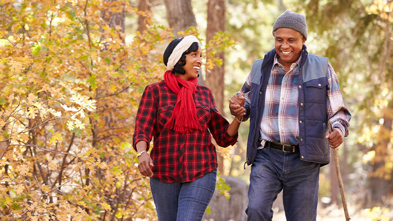 older couple hiking through the autumn woods