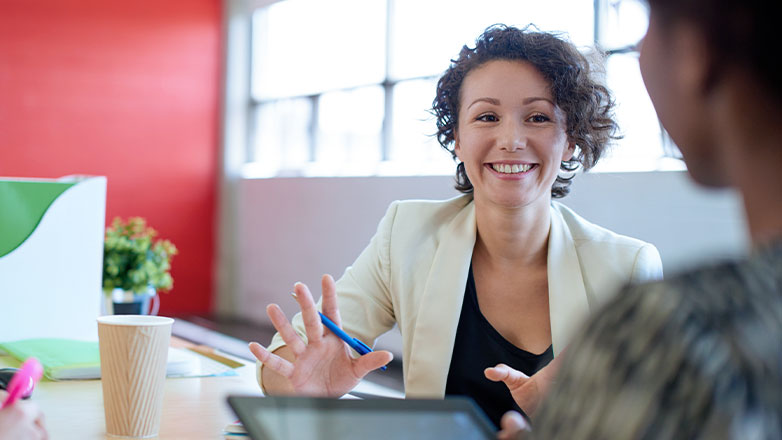 smiling woman holding pen meeting with client