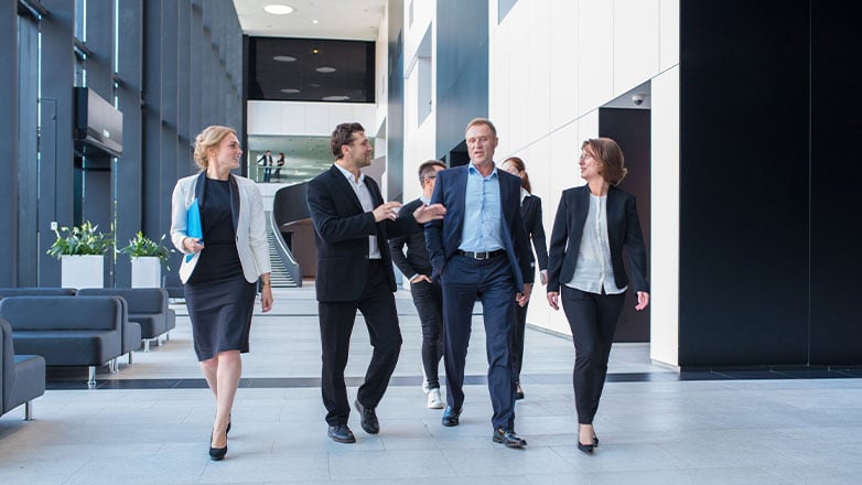 team of employees walking together down office hallway