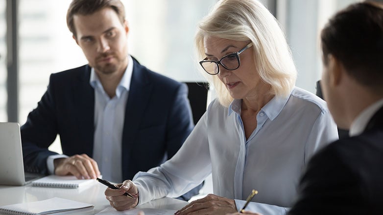 Woman focused on talking to two male co-workers about a project.