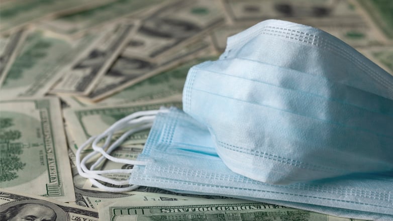 medical masks sitting on us dollars