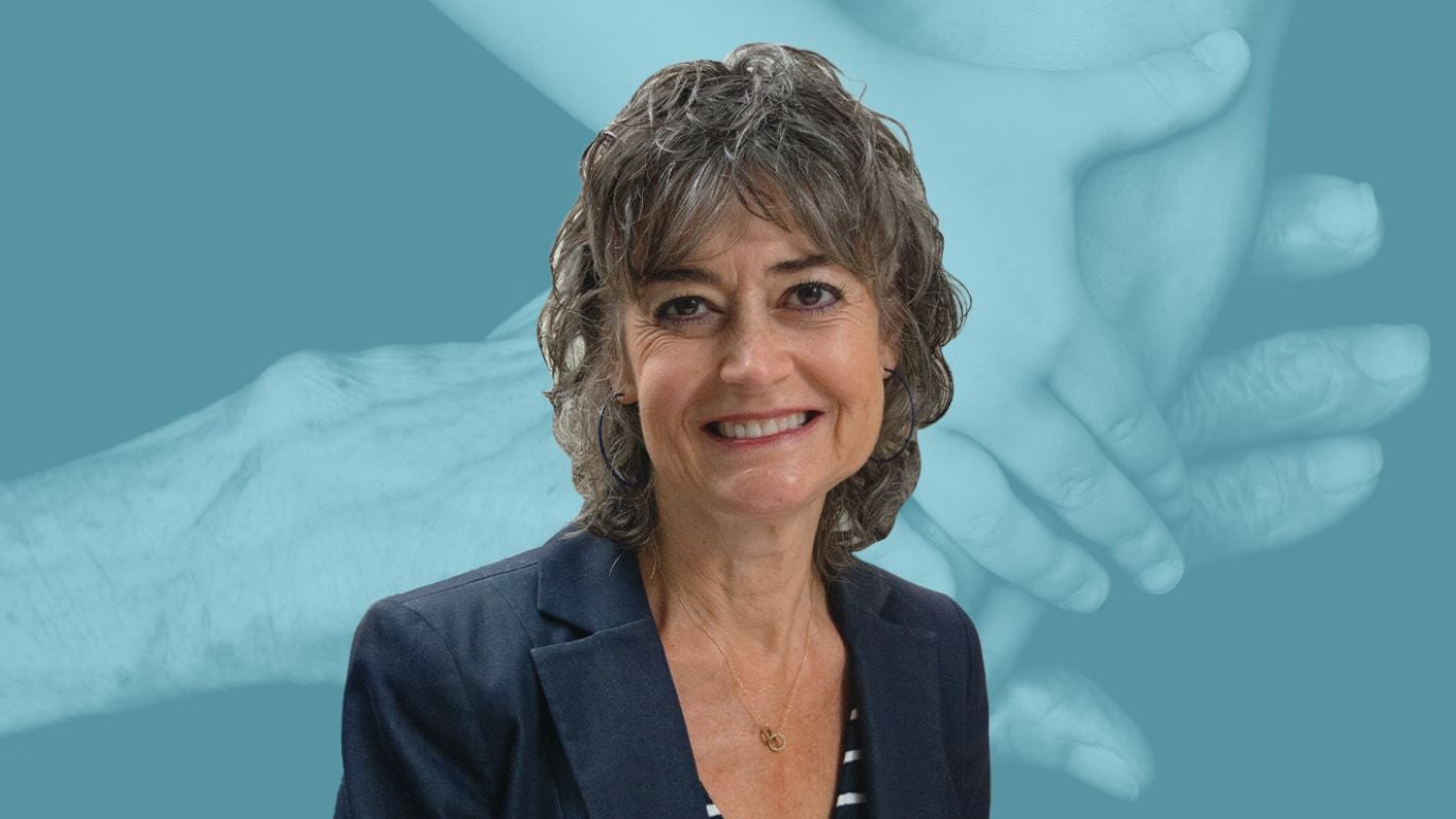 Person posed against a blue-toned background featuring multiple generations’ hands stacked together.