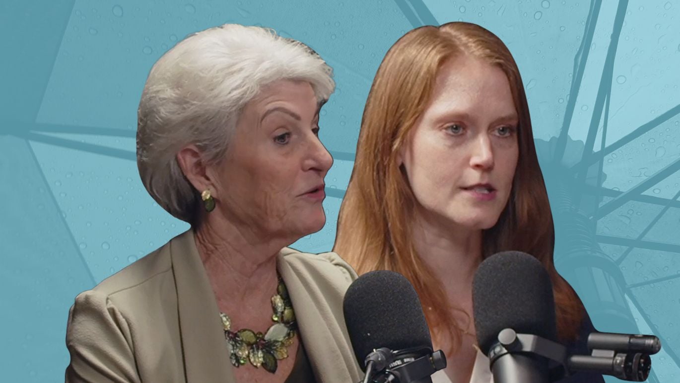 Two women speaking into microphones against a blue-toned umbrella background.