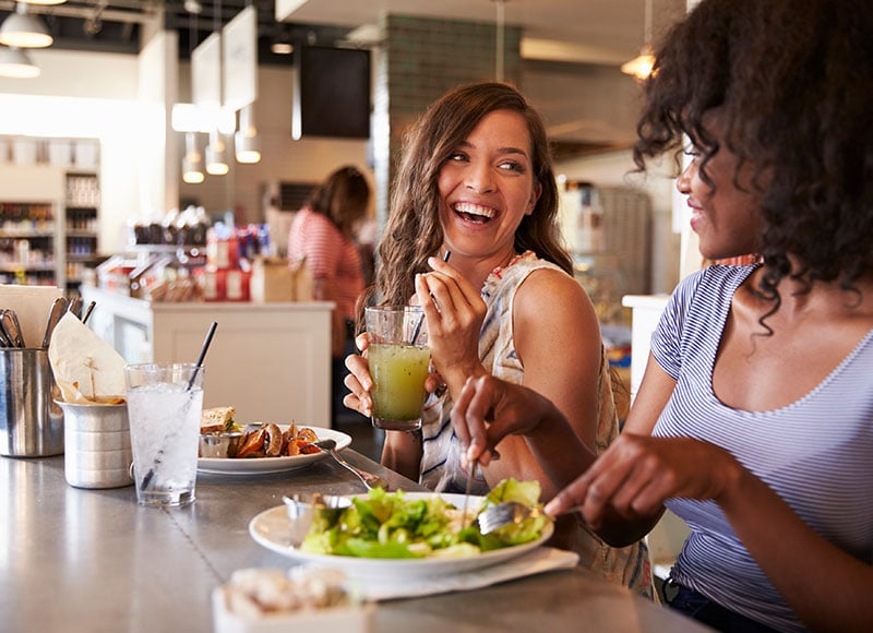 Two female friends grab lunch together at a restaurant.