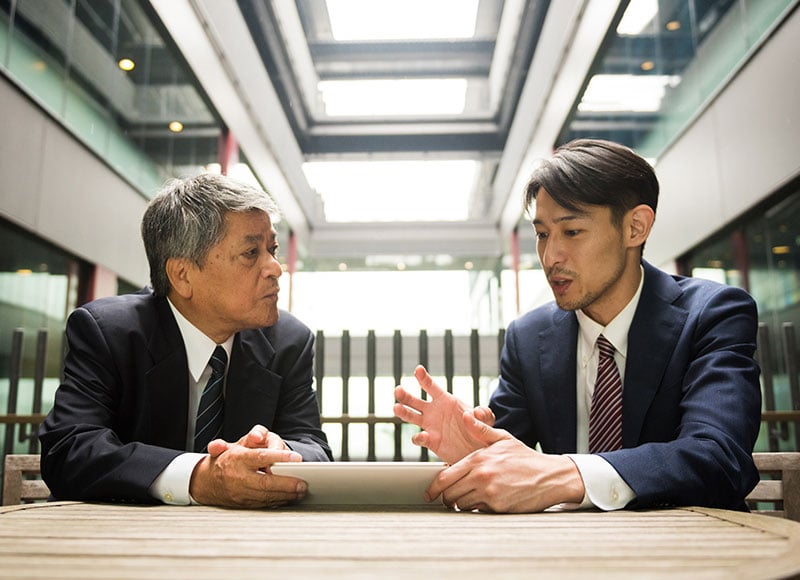 Father and adult son discuss their future plans for their family business.