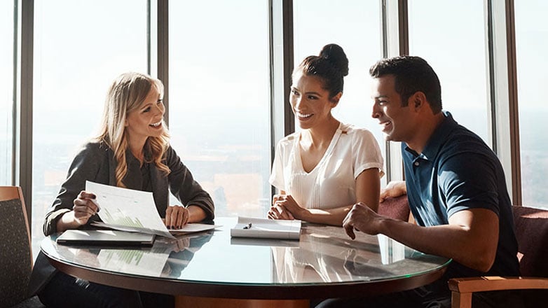 Young couple meets with a financial advisor at their office.