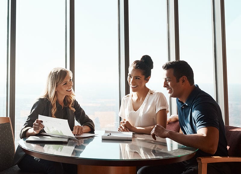 Young couple meets with a financial advisor at their office.